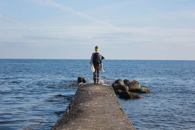 Rear view of woman standing on beach