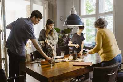 Family helping each other while setting up dining table at home