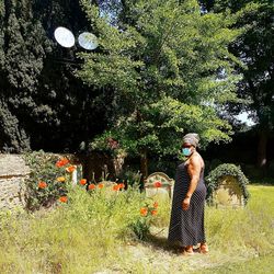 Full length of woman standing by flowering tree