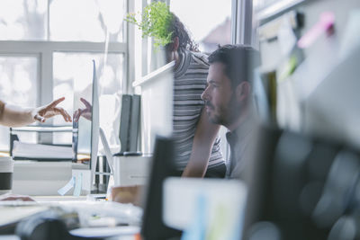 Business people working at desk reflecting on computer monitor in office