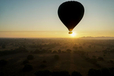 Hot air balloon flying over landscape of bagan during sunrise