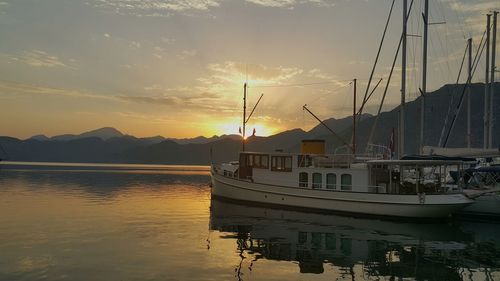 Sailboats in sea at sunset