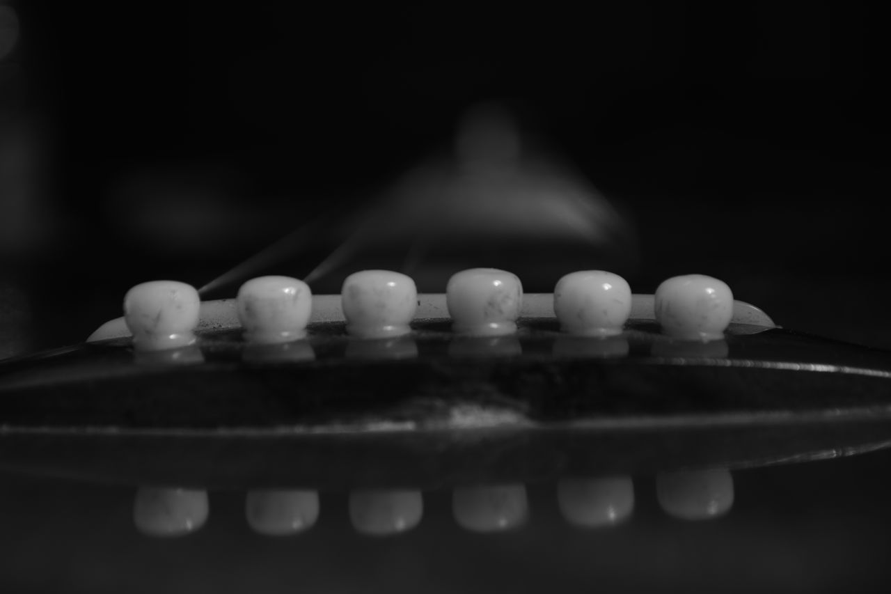 CLOSE-UP OF GUITAR WITH BLACK BACKGROUND