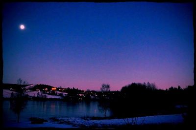 Scenic view of landscape against clear sky at dusk