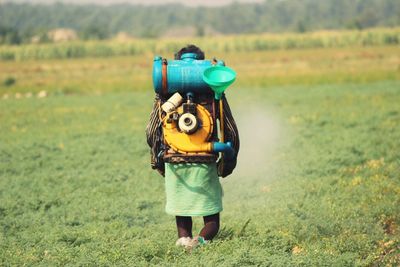 Rear view of woman standing in field