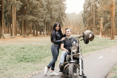 Full length of woman riding motorcycle on road