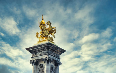 Low angle view of statue against cloudy sky