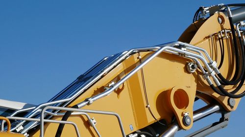 Close-up of yellow metal against sky