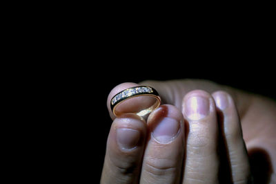 Close-up of woman hand against black background