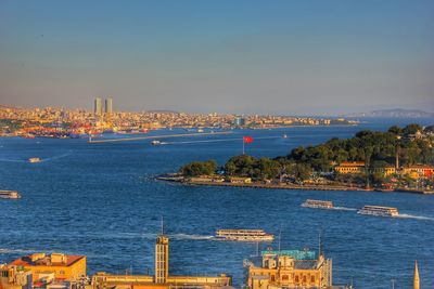 Boats in sea with city in background