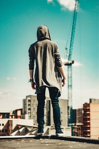 Full length of man standing by cityscape against sky