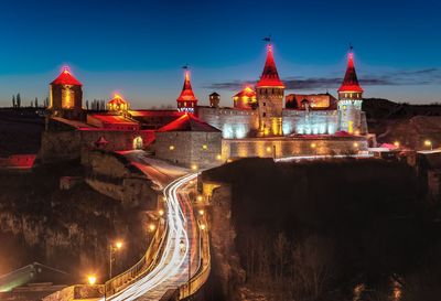 Illuminated buildings in city against sky at night