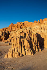 Scenic view of rock formations in a desert canyon against clear blue sky