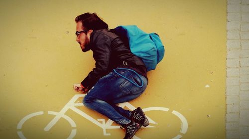 Midsection of man sitting against wall