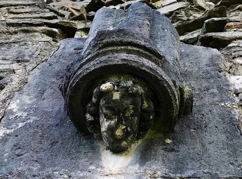 Close-up of old statue against wall