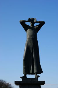 Low angle view of statue against clear blue sky