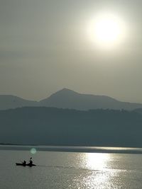 Scenic view of sea and silhouette mountains against sky