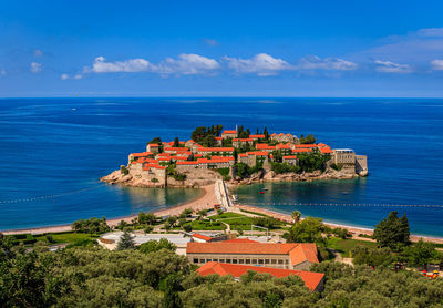 High angle view of townscape by sea against sky