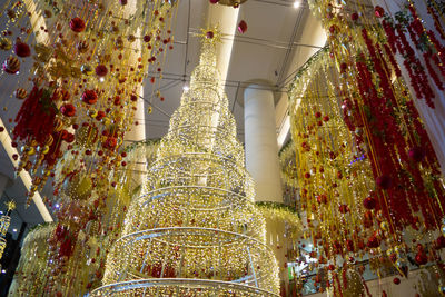 Low angle view of illuminated lanterns hanging on ceiling of building