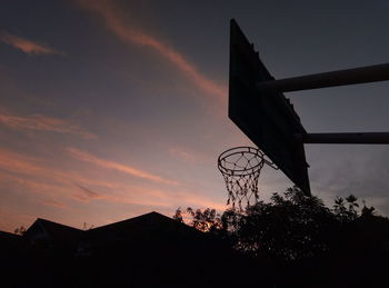 Low angle view of basketball hoop against sky during sunset