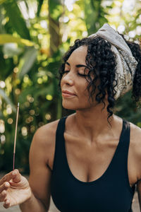 Mature woman smelling incense stick at wellness resort