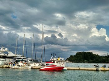 Sailboats moored in sea against sky