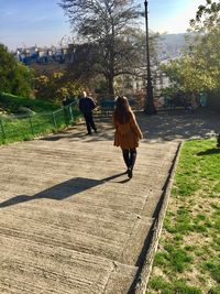 Rear view of woman walking on footpath