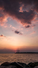 Silhouette of sailboat in sea during sunset