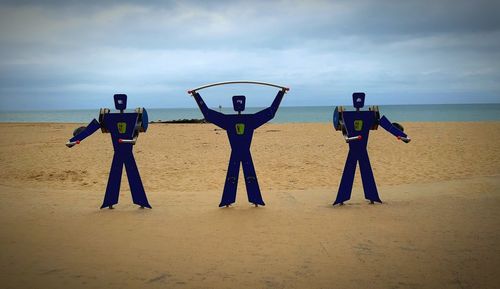 People standing on beach against sky