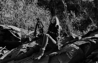 Woman sitting on rock in forest