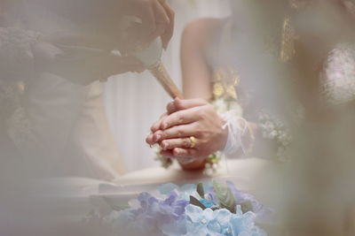 Cropped image pouring water on woman hands