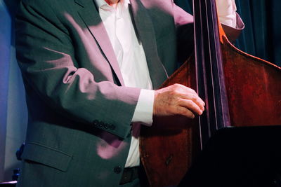 Midsection of musician playing double bass
