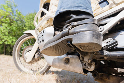 Low section of man riding motorcycle on field