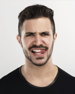 Portrait of smiling young man against white background