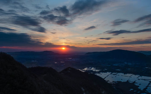 Scenic view of dramatic sky over mountains during sunset