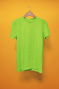Green paper hanging against orange wall