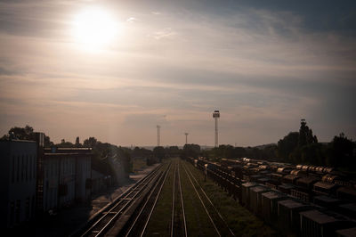 Railroad tracks against sky during sunset