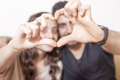 Midsection of woman holding hands against white background