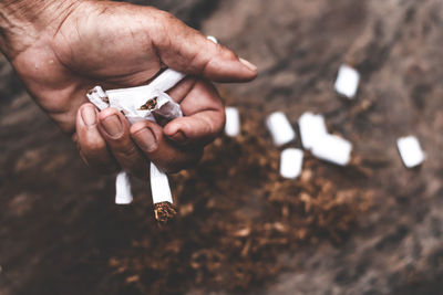 Cropped hand holding cigarettes outdoors