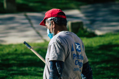 Young man looking away while standing on field