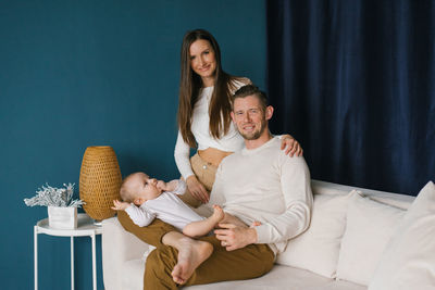 Happy family, mother and father sitting on the couch and happy together