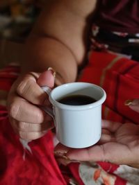 Midsection of woman holding coffee