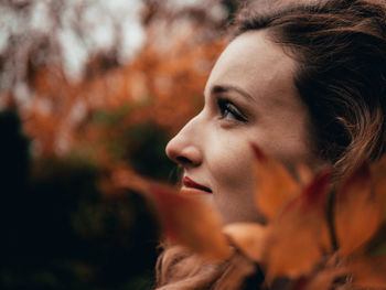 Side view of thoughtful young woman looking away at park during autumn