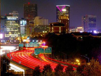 Illuminated buildings in city against sky at night