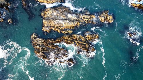 High angle view of rock formation in sea against sky