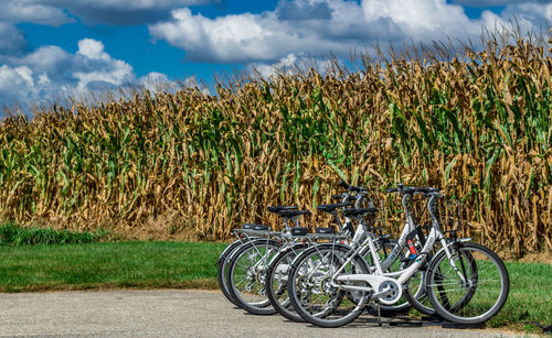 Bicycles on field against sky