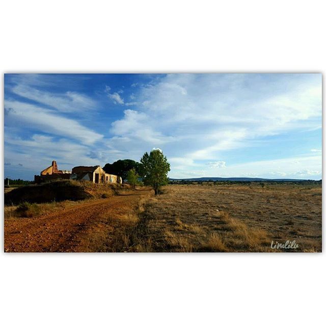 BUILT STRUCTURE ON LANDSCAPE AGAINST CLOUDY SKY