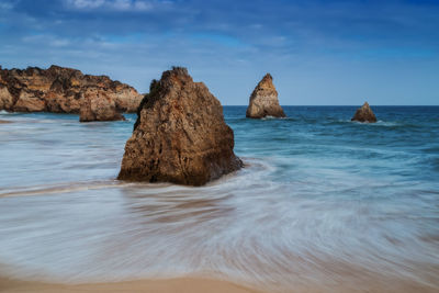 Rocks on sea shore against sky