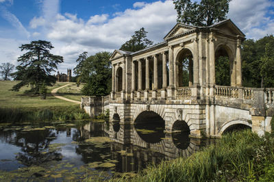 Arch bridge over lake against buildings