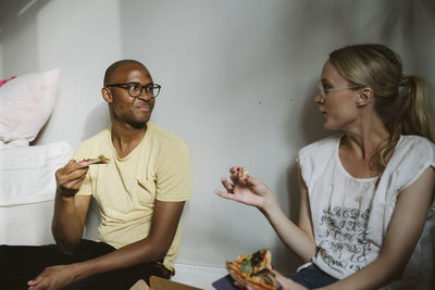 Couple sitting on floor and having pizza